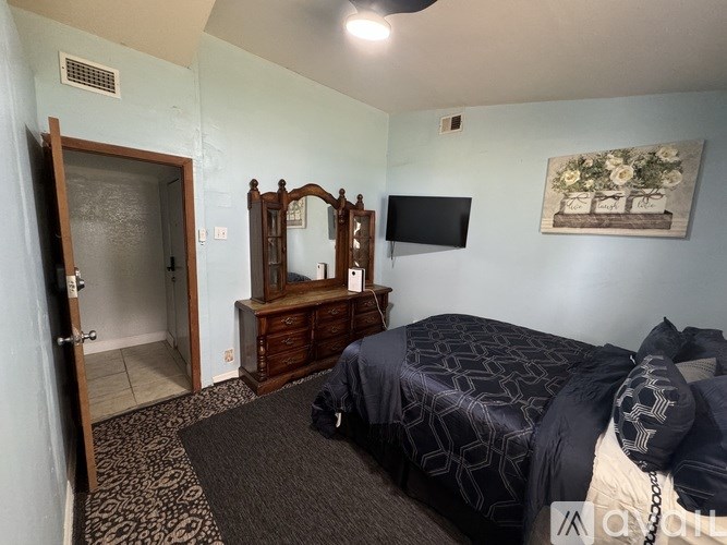 A bedroom with a bed, a dresser, and a mirror.