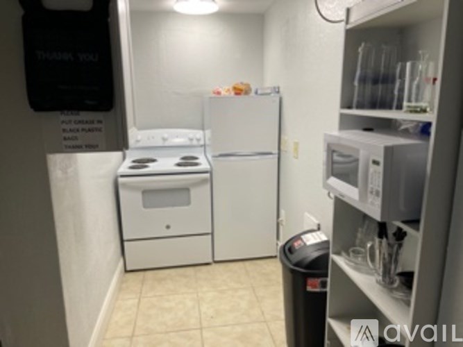 A small kitchen with a fridge, microwave, and stove.