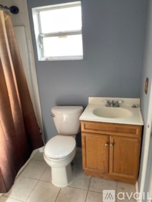 A small bathroom with a toilet, sink and a window.