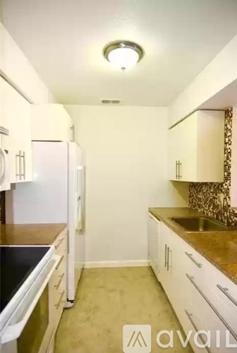 A kitchen with white cabinets and a black counter top.