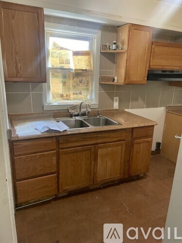 A kitchen with wooden cabinets and a window.