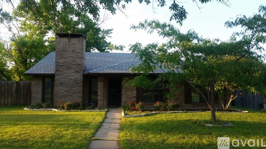 A house with a stone chimney and a tree in front.