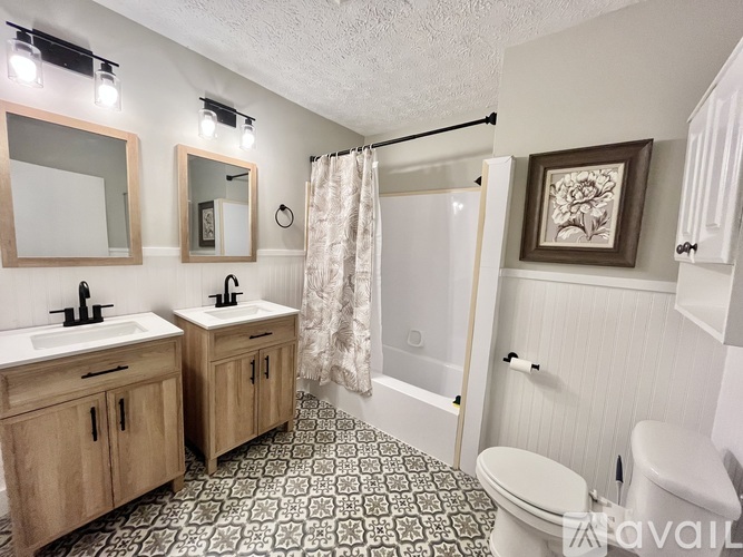 A bathroom with two sinks and a shower.