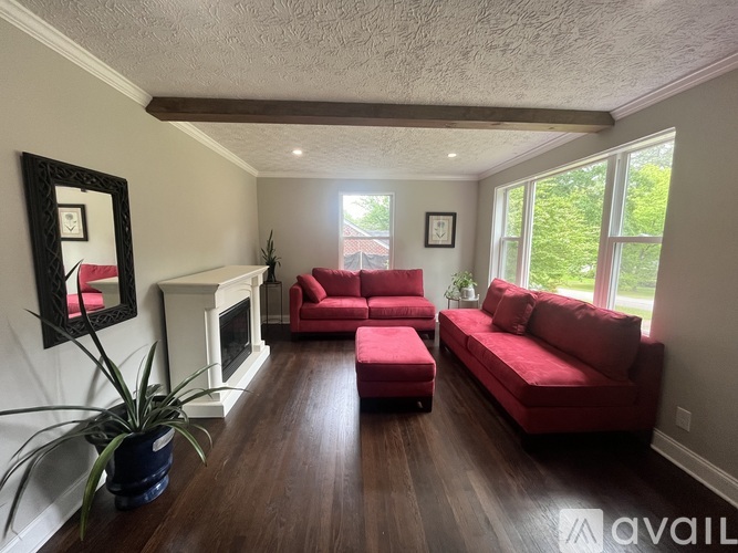 A living room with a red couch and a fireplace.