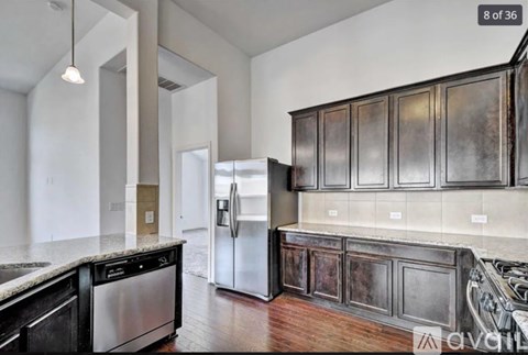 A kitchen with dark wood cabinets and stainless steel appliances.