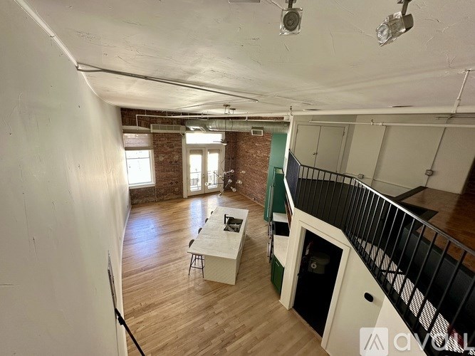 A kitchen island with a countertop and cabinets in a room with a brick wall and a window.