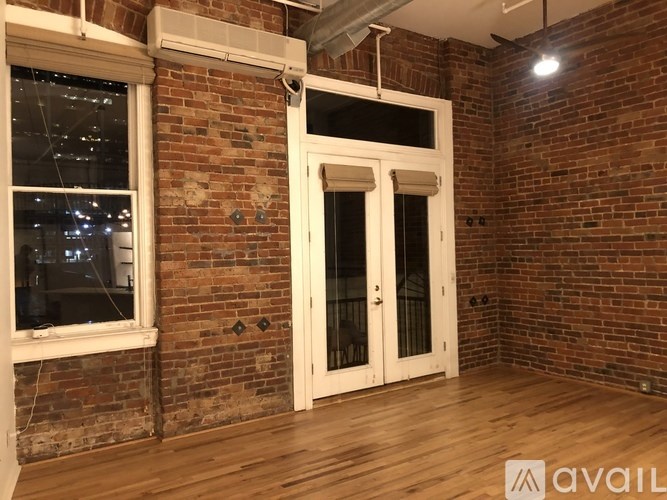 A room with a brick wall and a wooden floor.