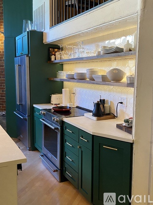 A kitchen with green cabinets and a white countertop.