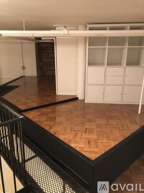 A room with wooden flooring and white walls.