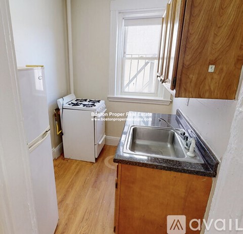A kitchen with wooden cabinets and a window.