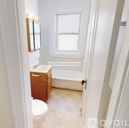 A small bathroom with a toilet, sink and window.