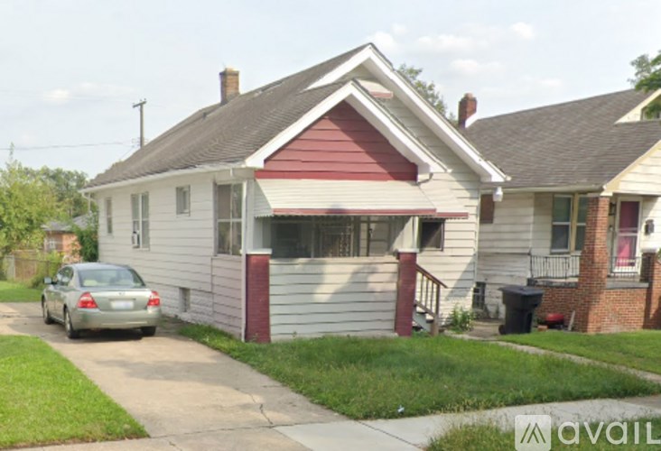 A house with a red roof and a car parked in front.