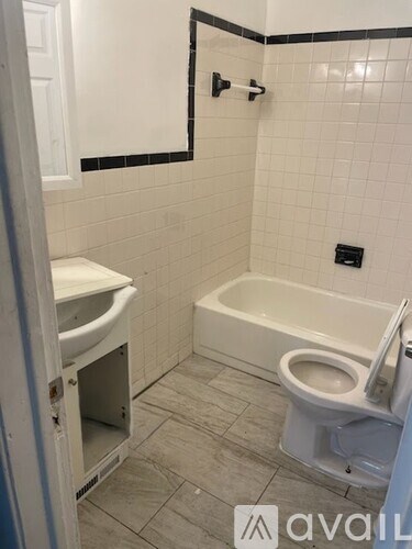 A bathroom with a toilet, sink, and bathtub.