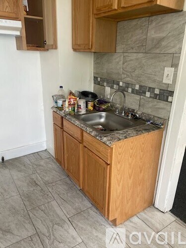 A kitchen with wooden cabinets and a marble backsplash.