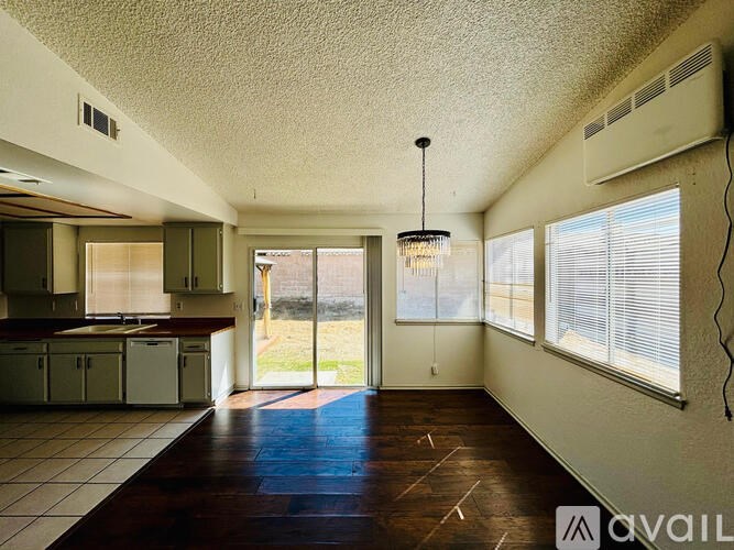 A room with a kitchen area and a dining table.