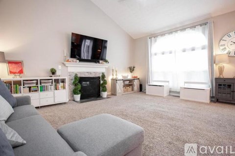 A living room with a grey sofa and a fireplace.