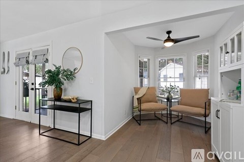 A living room with a glass table and two chairs.