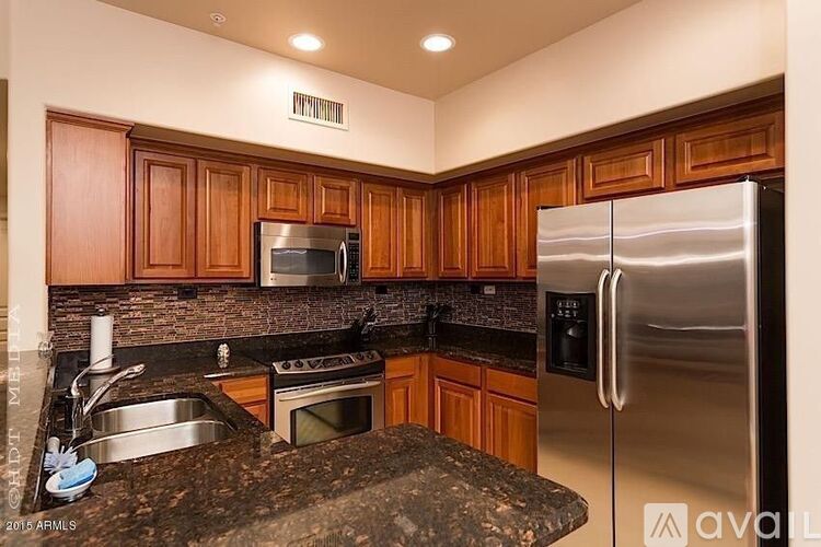 A kitchen with wooden cabinets and granite countertops.
