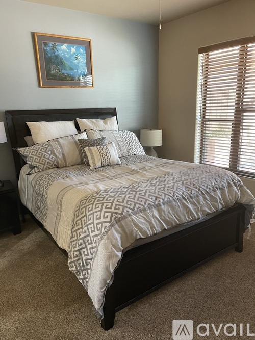 A bed with a patterned comforter and pillows in a bedroom.