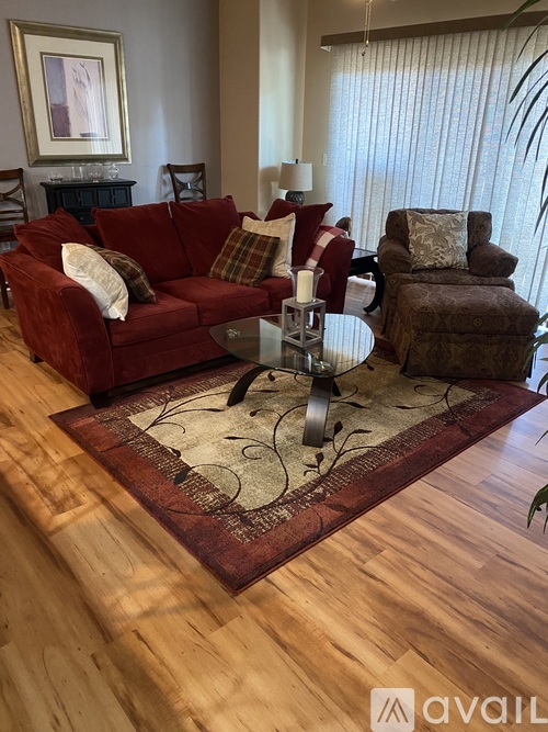 A living room with a red couch and a brown chair.