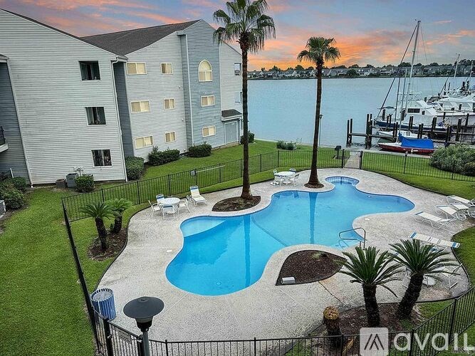A pool surrounded by palm trees and chairs.