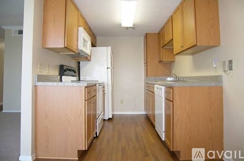 A kitchen with wooden cabinets and appliances.