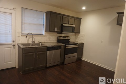 A kitchen with dark wood floors and white subway tiles.