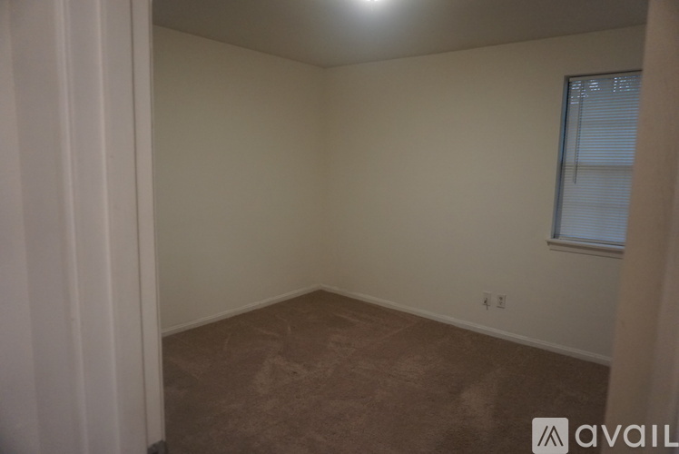 A room with a window and a carpeted floor.