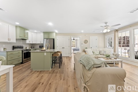 A kitchen with green cabinets and a wooden floor.