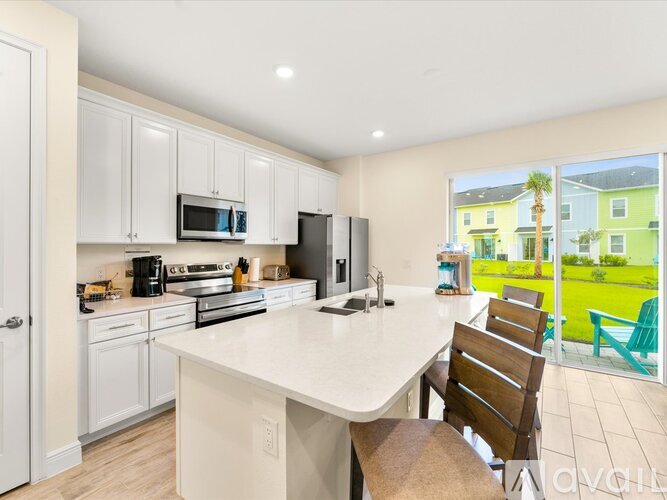 A kitchen with a white countertop and wooden chairs.