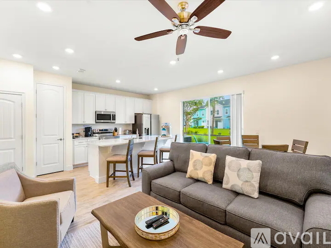 A living room with a grey couch and a ceiling fan.