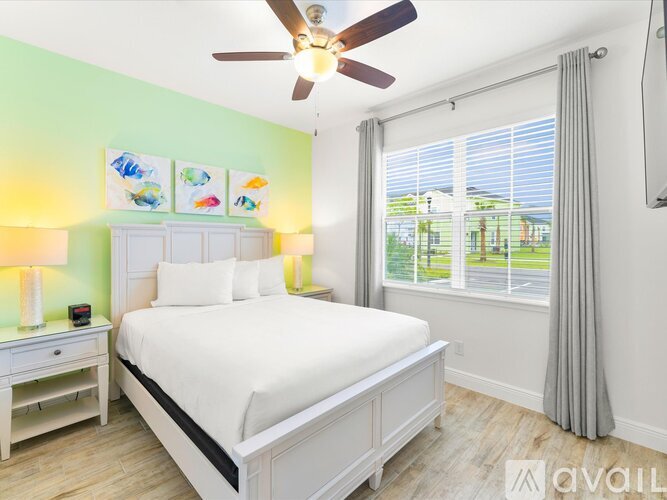 A bedroom with a bed, nightstand, and a ceiling fan.