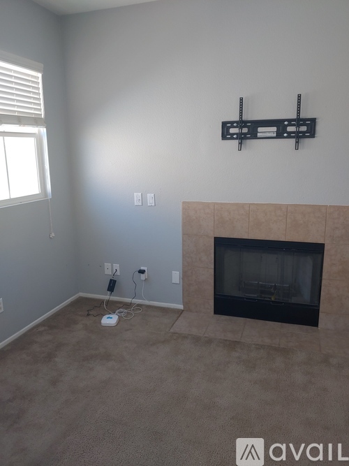 A room with a fireplace and a wall-mounted shelf.