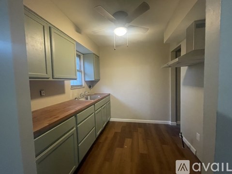 A kitchen with wooden countertops and green cabinets.