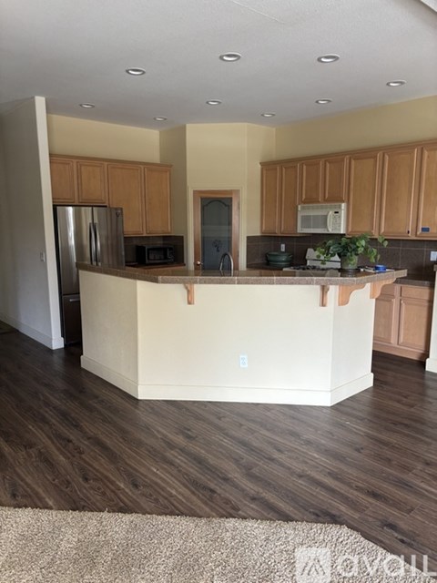 A kitchen with wooden cabinets and a white island.