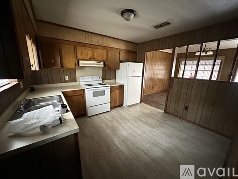 A kitchen with wooden cabinets and a white refrigerator.