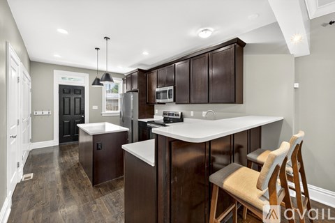 A kitchen with dark brown cabinets and a white countertop.