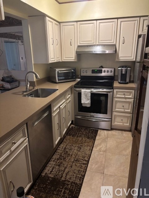 A kitchen with a sink, stove, and oven.