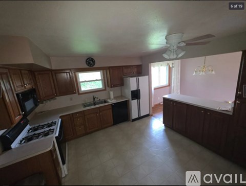 A kitchen with wooden cabinets and a white stove top oven.