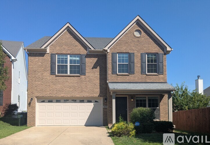 A two-story house with a garage is available for sale.