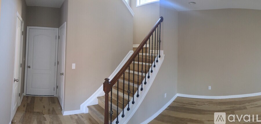 A staircase with a wooden banister and a white door at the bottom.