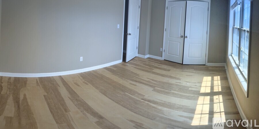 A room with wooden flooring and white walls.