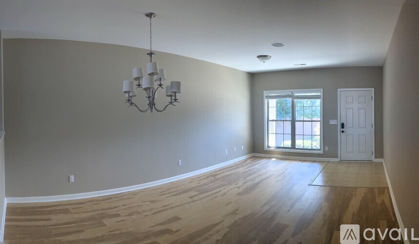 A room with wooden floors and a chandelier.