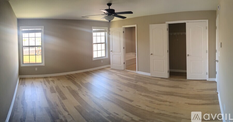 A room with wooden flooring and a ceiling fan.