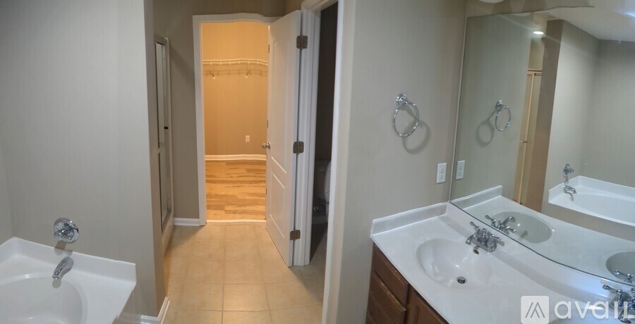 A bathroom with a sink, mirror, and a shower.