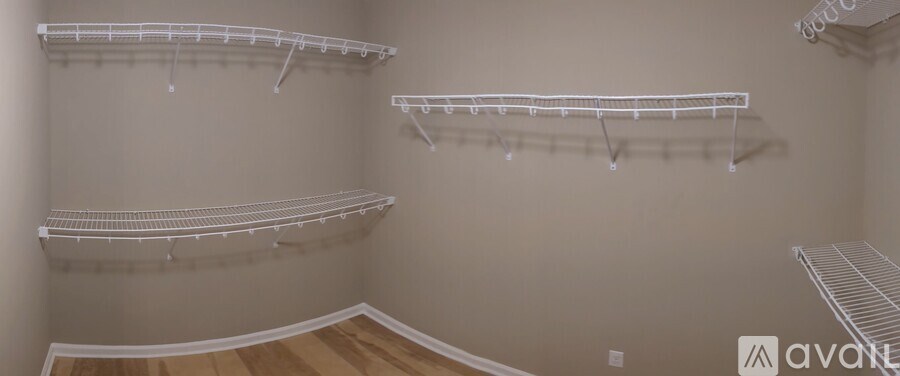 A room with white shelves and wooden flooring.