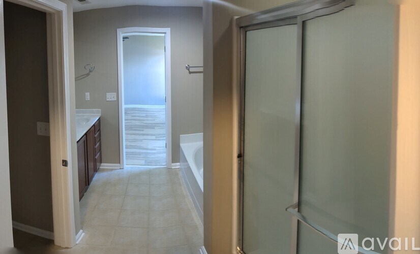 A bathroom with a glass shower door and a toilet visible through the doorway.