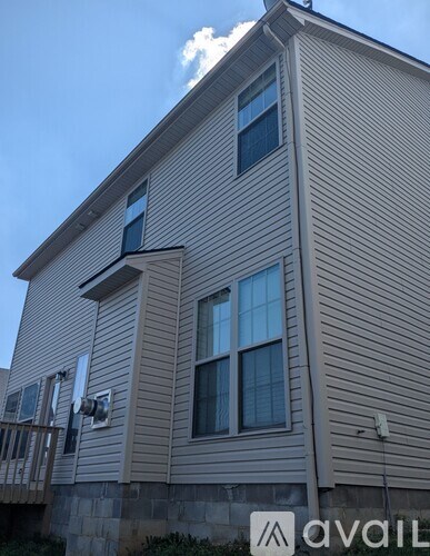 A house with a beige siding and a balcony on the second floor.