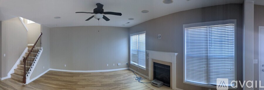 A living room with a fireplace and a staircase.