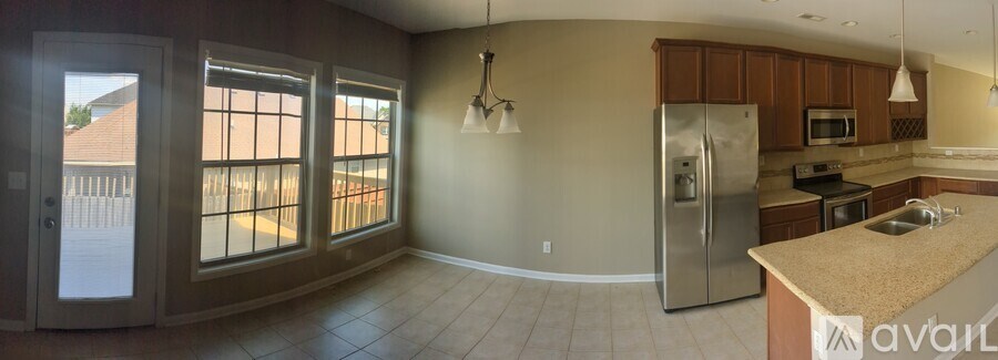 A kitchen with a refrigerator, microwave, and oven.